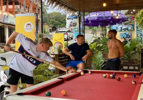 a group of men playing a game of pool at Vibes Samui Hostel and Cafe' in Ban Nai Na