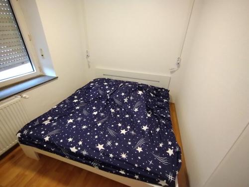 een klein bed in een kleine kamer met sterren bij Ferienhaus in Berenbach in Berenbach