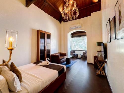 a bedroom with a large bed and a chandelier at Gulf Hotel Mumbai- The Boutique Hotel Colaba Mumbai in Mumbai
