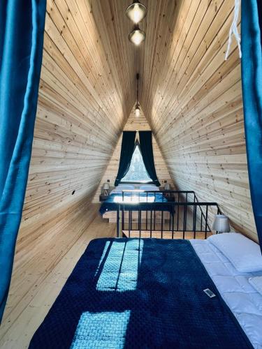 a bedroom with a bed in a wooden room at Arsha View in Kazbegi