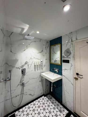 a bathroom with a sink and a shower at Gulf Hotel Mumbai- The Boutique Hotel Colaba Mumbai in Mumbai