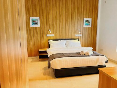 Holiday Villa的卧室里有一张床，床上放着两条毛巾。