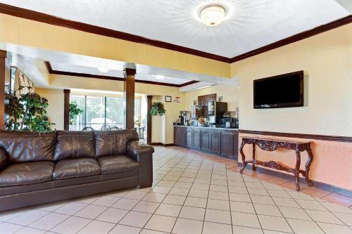 a living room with a couch and a flat screen tv at Super 8 by Wyndham Jackson Ridgeland in Jackson