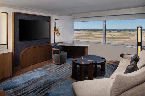 a living room with a television and a couch and a table at Grand Hyatt DFW Airport in Irving