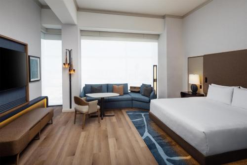 a hotel room with a bed and a couch at Grand Hyatt DFW Airport in Irving