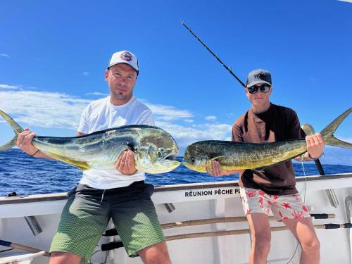 Dos hombres en un bote sosteniendo un pez grande en Port de saint leu location Bateau avec skyper 2H o693-40-58, en Saint-Leu