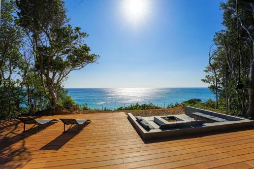 een houten terras met uitzicht op de oceaan bij UMIBE Terrace in Shima