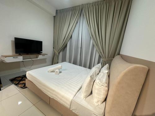 una camera d'albergo con un letto e una televisione di Golden Triangle Suites klcc By Majestic a Kuala Lumpur