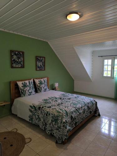 a bedroom with a bed in a green wall at Location saisonnière Chez Paulette in Cilaos