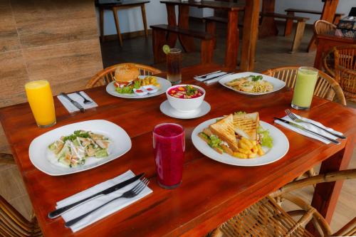 een houten tafel met borden met eten erop bij Bunut Bungalow in Nusa Penida