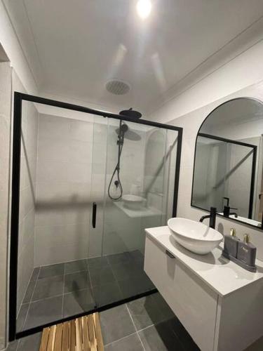 a bathroom with a shower and a sink and a mirror at Guesthouse Nature Escape Sleeps up to 6 in Heathcote