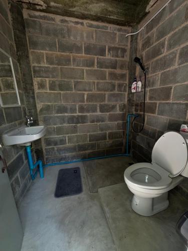 une salle de bain en brique avec toilettes et lavabo dans l'établissement Ko Kut Nature Camp, à Ko Kood
