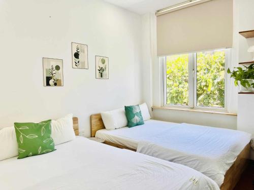 two beds in a room with a window at Chiri Homestay in Thôn Trường Giang