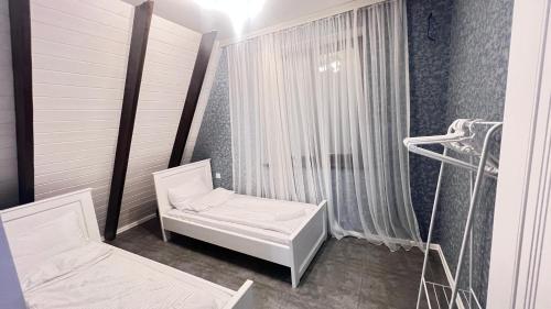 een ziekenhuiskamer met 2 bedden en een raam bij Gabala Garden & Mountain View Villa in Gabala