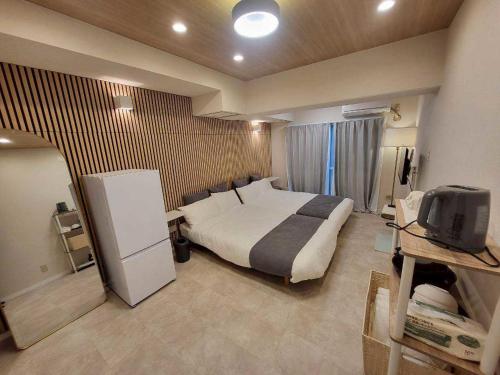 a hotel room with a bed and a tv at プレアデス皆実 in Hiroshima