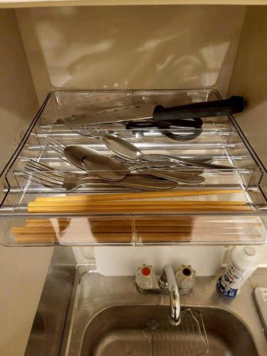 a drawer with a bunch of utensils and a sink at プレアデス皆実 in Hiroshima