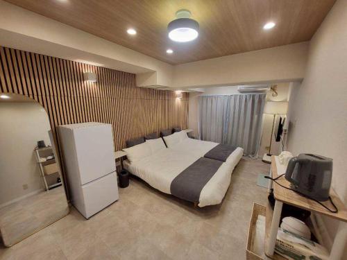 a bedroom with a bed and a tv in it at プレアデス皆実 in Hiroshima
