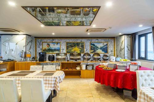 cocina con mesa y mantel rojo en Aaron Riverview Hotel, en Vientiane