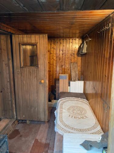 a bedroom with a bed in a wooden room at Leonovs in Almaty