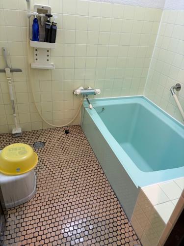 a bathroom with a blue tub with a toilet at Ogoto House Rake Omi in Otsu