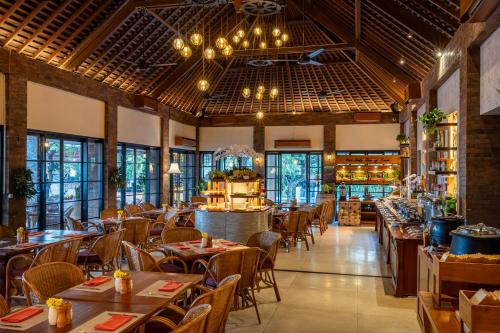een restaurant met tafels en stoelen en een bar bij Kuta Seaview Beach Resort in Kuta