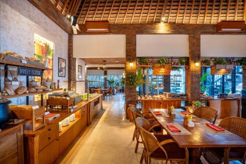 een restaurant met houten tafels en stoelen in een kamer bij Kuta Seaview Beach Resort in Kuta