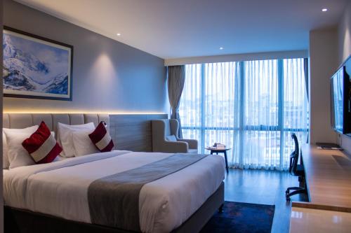 una habitación de hotel con una cama y una ventana grande en Best Western Plus Kathmandu Hotel, en Katmandú