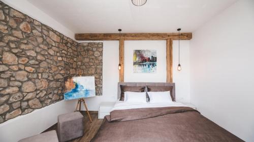 une chambre avec un mur en pierre et un lit dans l'établissement Luxury Villa Mihaela beachfront by Villas Guide, à Jadranovo