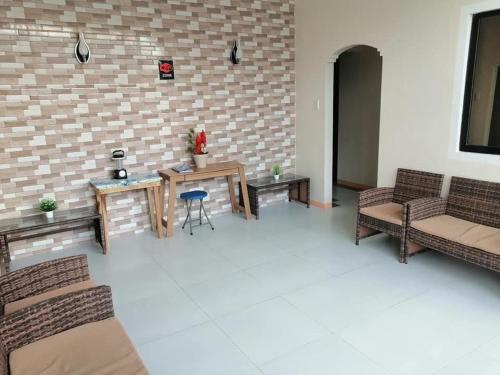 ein Wohnzimmer mit Möbeln und Ziegelwand in der Unterkunft J and J Residence in General Luna