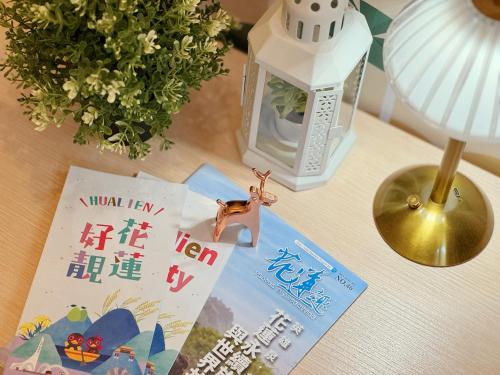 a table with a lamp and a book and a lampurrection at Finders Hotel Hualien Station in Hualien City