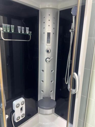 ein Badezimmer mit einer Dusche mit Sitzgelegenheit in der Unterkunft Starway Hotel in Länkäran