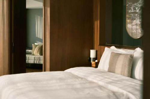 北京市にあるThe Purple Horse Hotel Beijingの白いベッドと鏡のある寝室