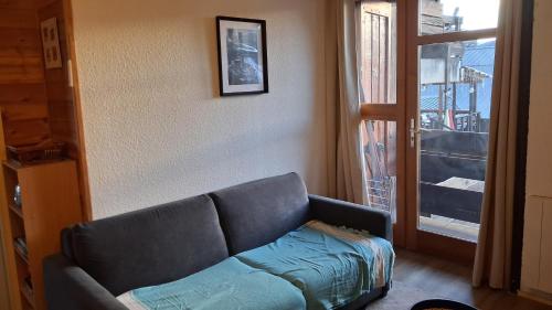 a living room with a couch and a window at Les Isards Pied des pistes in Ax-les-Thermes