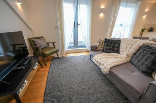 a living room with a couch and a television at The Sea Pearl in Eastbourne