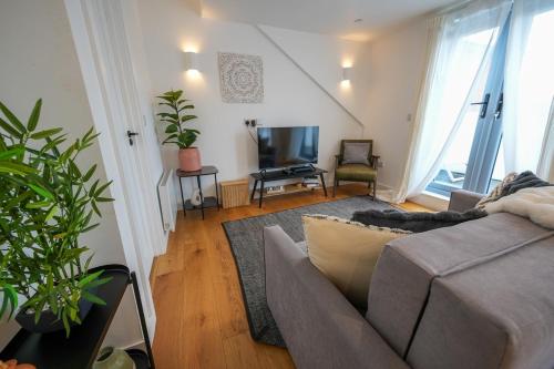 a living room with a couch and a television at The Sea Pearl in Eastbourne