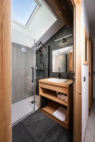 a bathroom with a glass shower and a sink at Chalet Valora in Le Grand-Bornand