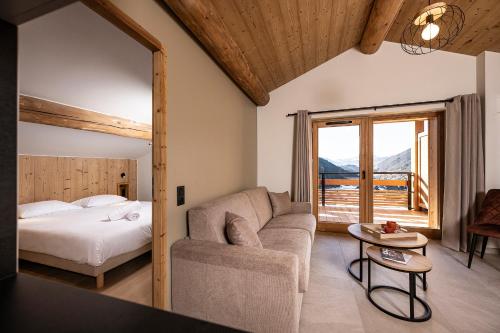 a bedroom with a bed and a couch and a table at Chalet Valora in Le Grand-Bornand