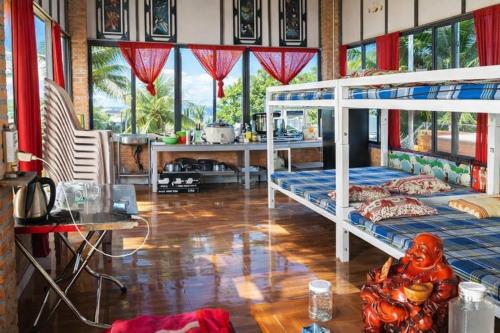 ein Schlafzimmer mit zwei Etagenbetten und einem Tisch in der Unterkunft Vườn Dừa Cam Bình 1 in La Gi