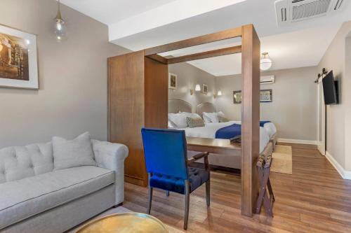 a bedroom with a bed and a desk and a couch at The Colonial Inn, an Ascend Collection Hotel in Hillsborough