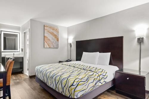 オレンジパークにあるSuburban Studios Orange Park - Jacksonville near Naval Air Stationの大きなベッドと机があるホテルの部屋