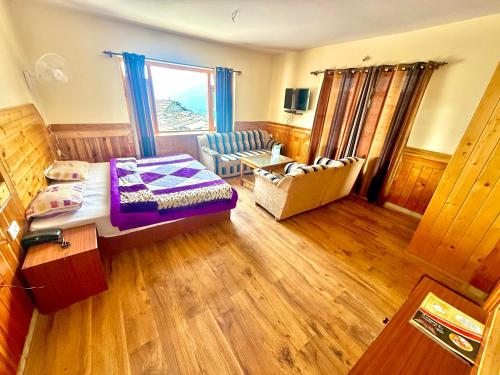 a room with a bed and a chair and a window at Cedar Valley Retreat in Jagatsukh