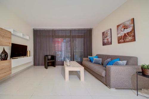 a living room with a couch and a table at Bright 1BR in the Heart of St Julians in St. Julianʼs