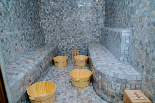 een kamer met vier houten krukjes in een bakstenen muur bij Baviecoresort in Ba Vì