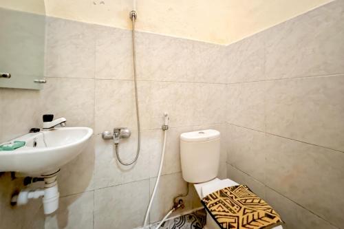 a bathroom with a toilet and a sink at Perdana Kasih Hotel Pemuda Klaten Mitra RedDoorz in Solo