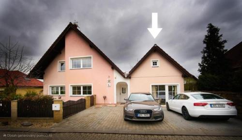 una casa con dos coches estacionados frente a ella en Bluestars Apartments, en Karlovy Vary