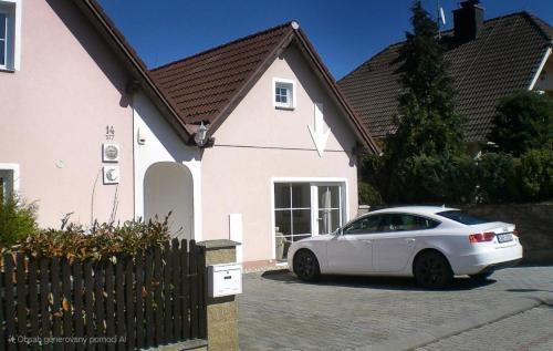 Un coche blanco aparcado delante de una casa en Bluestars Apartments, en Karlovy Vary