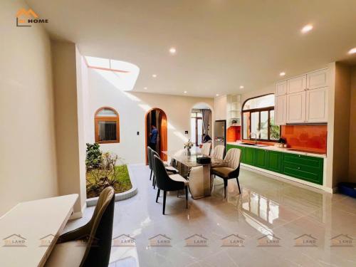une cuisine et une salle à manger avec une table et des chaises dans l'établissement Bi Home, à Phú Mỹ