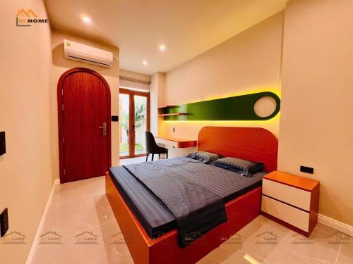une chambre avec un lit et un bureau dans l'établissement Bi Home, à Phú Mỹ