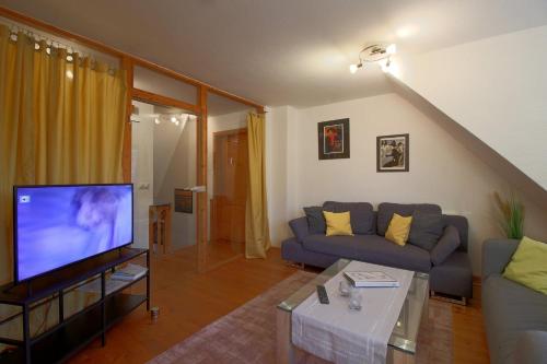 a living room with a couch and a flat screen tv at KA6 Haus Küstenzeit in Wremen