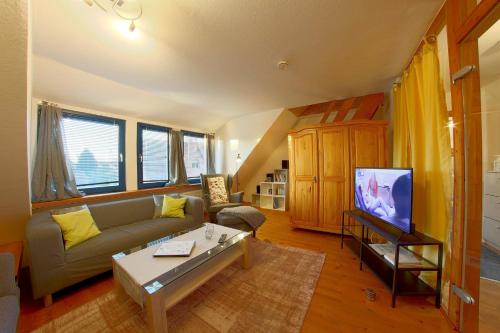 a living room with a couch and a tv at KA6 Haus Küstenzeit in Wremen